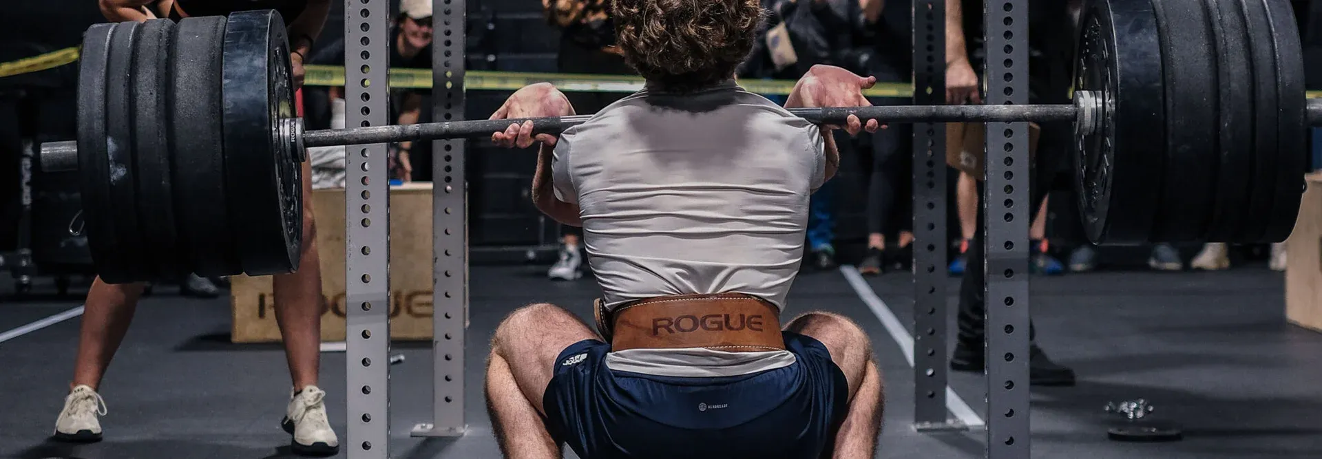 A member squatting heavy while the class cheers at Kalamazoo Strength in Kalamazoo